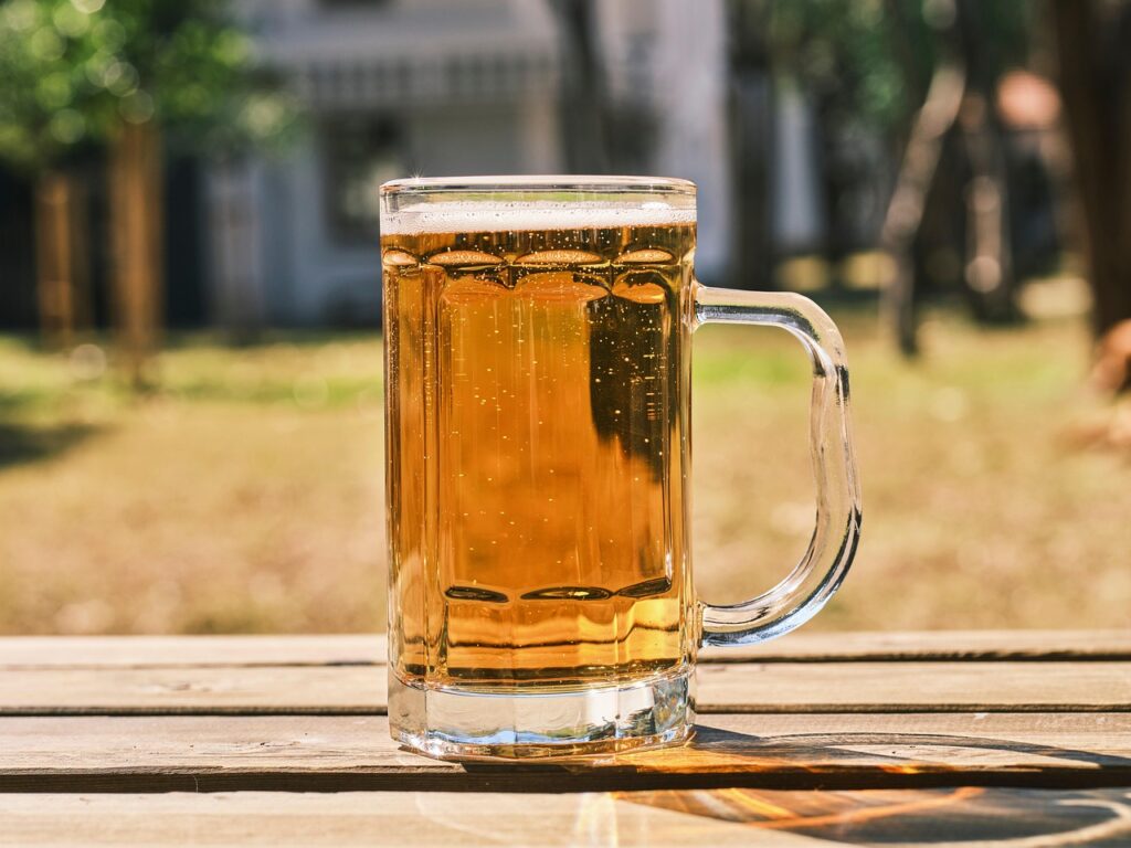 屋外テーブルに置かれた冷えたビールジョッキ