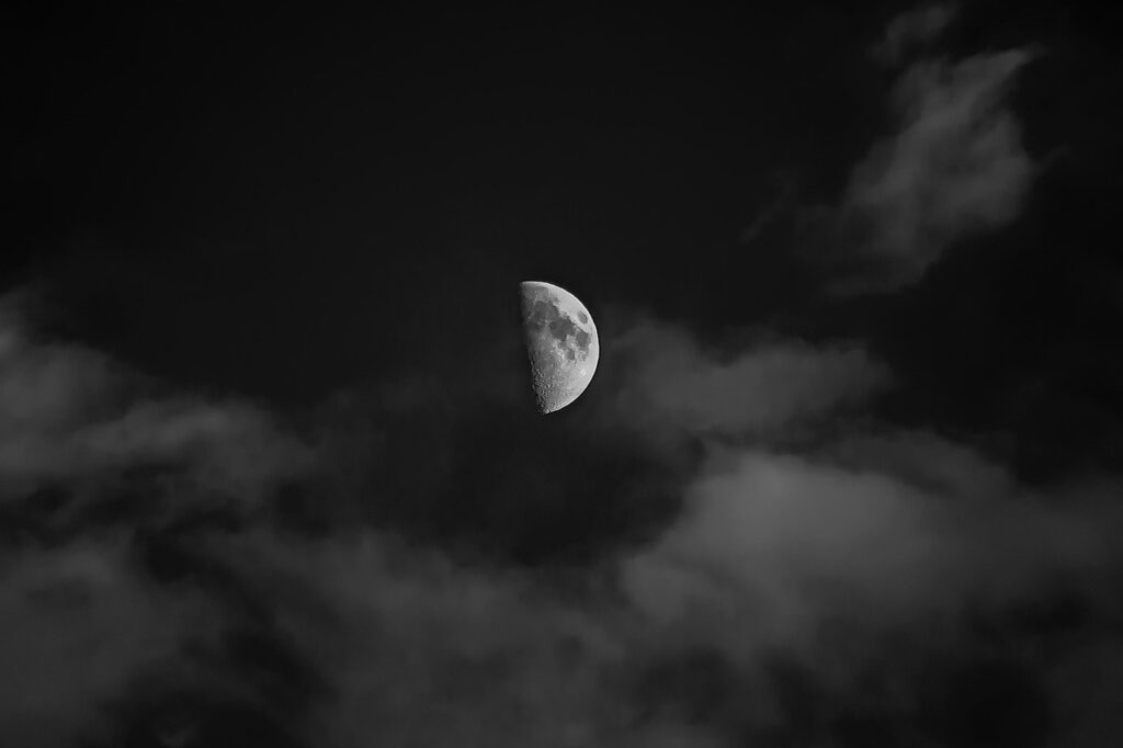 夜空に浮かぶ半月と流れる雲の静かな風景