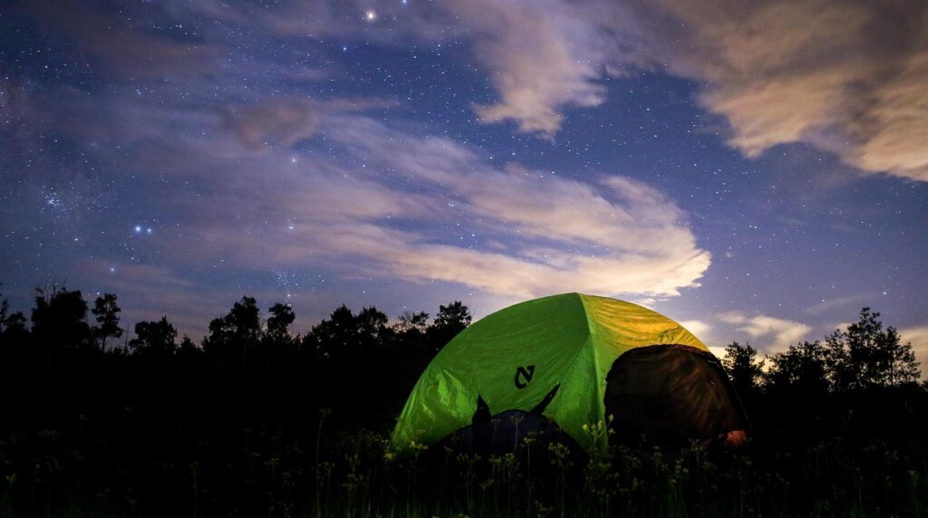 星空の下に設営されたソロテントと夜のキャンプ風景