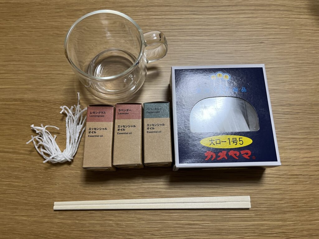 手作りアロマキャンドルに必要なガラス容器、キャンドル芯、精油、ソイワックスなどの材料一式。