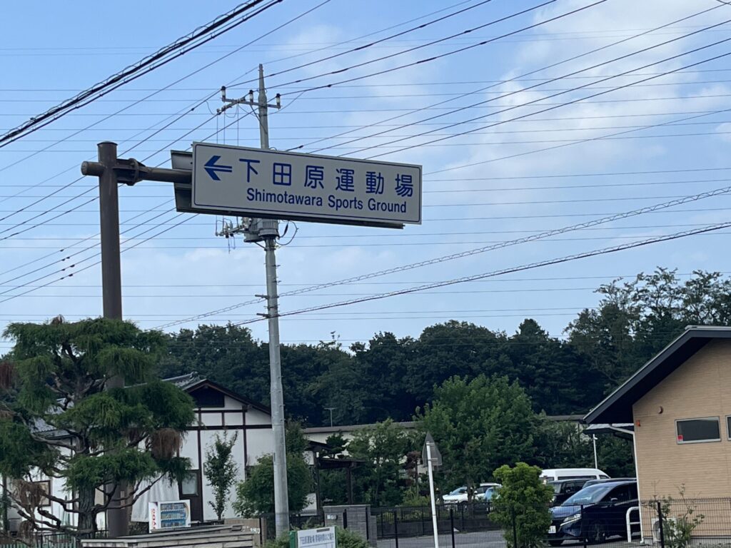 下田原運動場への案内標識。高間木キャンプ場へ向かう目印となる道路標識。