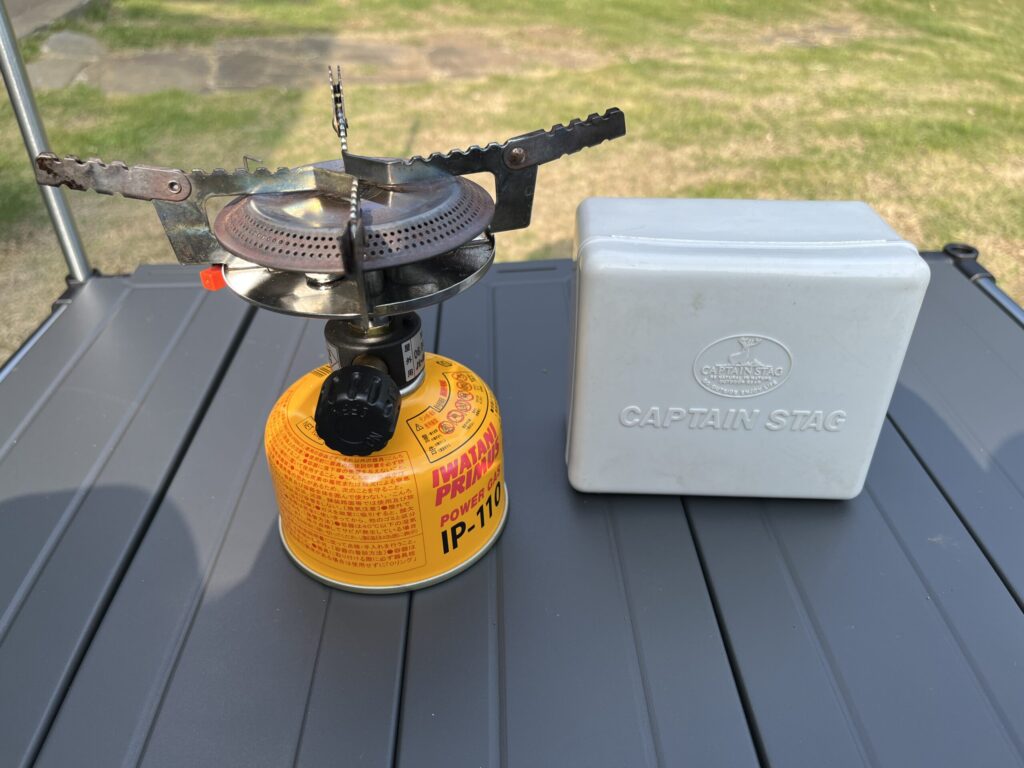 シングルバーナーとメスティンを並べたソロキャンプ用調理器具