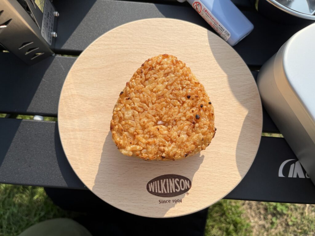 キャンプで焼いた香ばしい焼きおにぎり。木製プレートに盛り付けたソロキャンプ飯。